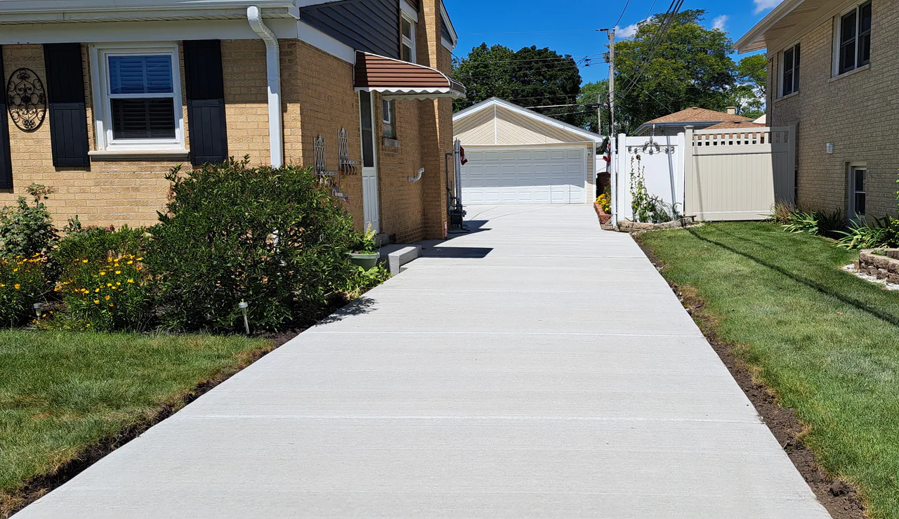 New concrete driveway at a tan-brick home