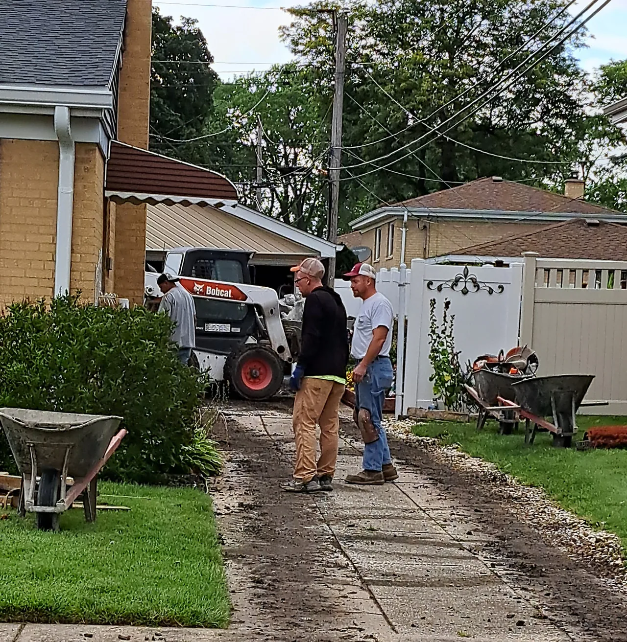Crew and excavator tearing out an old driveway